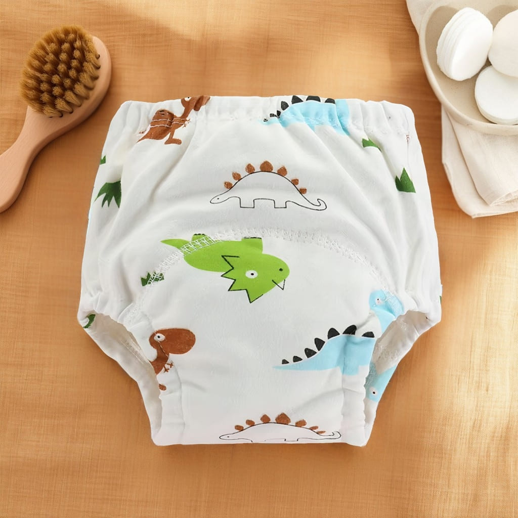 Culotte d’apprentissage bébé blanche avec motifs dinosaures colorés.