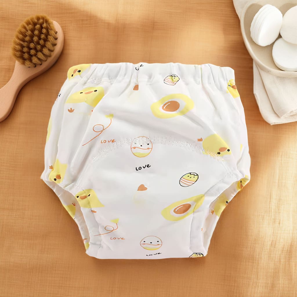 Culotte d’apprentissage bébé blanche avec motifs poussin jaune et oeufs.